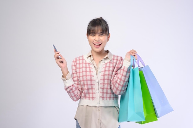 Mulher de cliente atraente segurando sacolas de compras sobre fundo branco