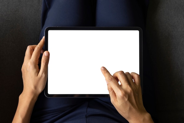 Mulher de close-up de mão com tela branca do tablet digital no sofá na sala de estar. Conceito de tecnologia, conexão, comunicação.