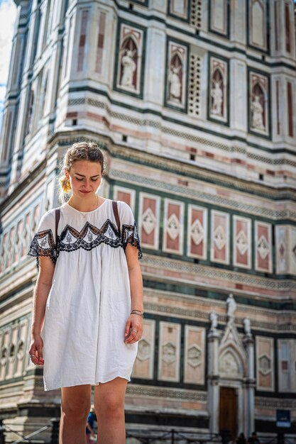 Foto mulher de comprimento completo de pé contra um edifício na cidade