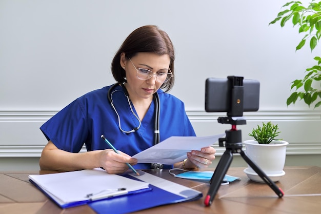 Mulher de consulta médica on-line falando com paciente usando videochamada