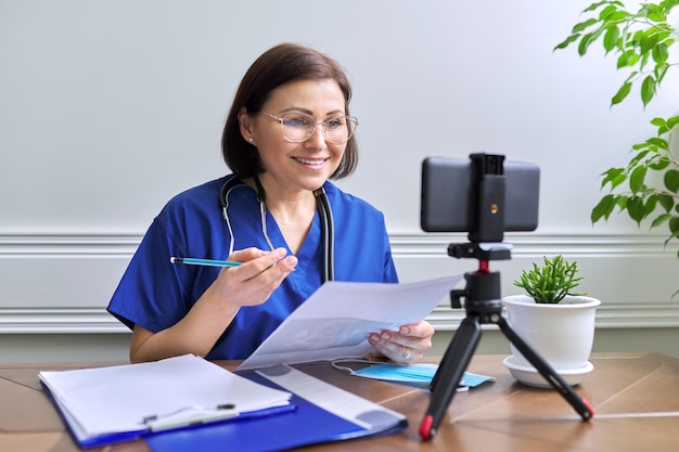 Mulher de consulta médica on-line falando com paciente usando videochamada