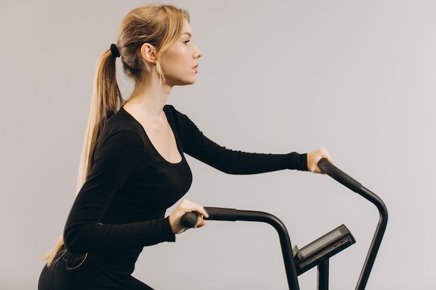 Mulher de crossfit fazendo treinamento cardio intenso na bicicleta de exercício