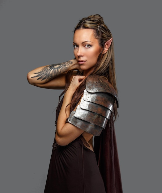 Foto mulher de elfo mágico em armadura isolada em um fundo cinza.
