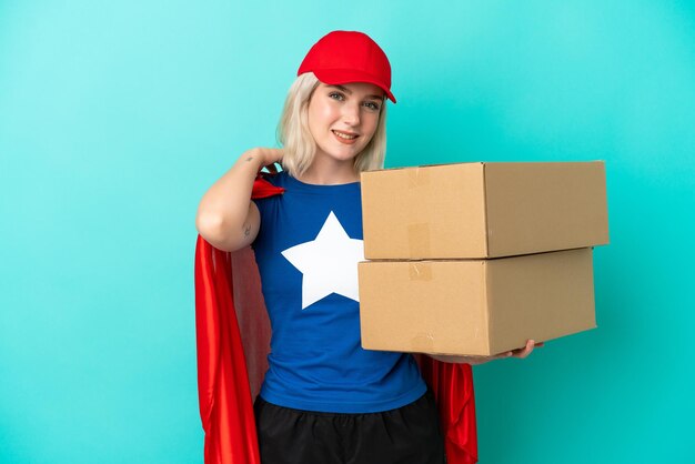 Mulher de entrega caucasiana de super-herói isolada em fundo azul rindo