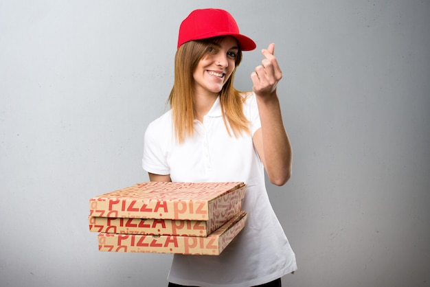 Foto mulher de entrega de pizza fazendo gesto de dinheiro em plano de fundo texturizado