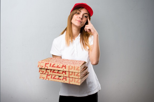 Mulher de entrega de pizza pensando em plano de fundo texturizado
