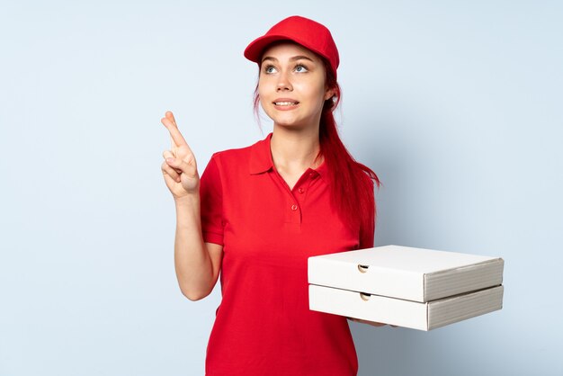 Mulher de entrega de pizza segurando uma pizza com dedos cruzando e desejando o melhor