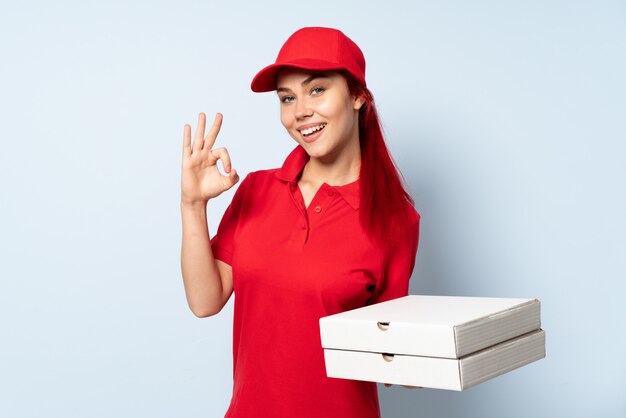 Mulher de entrega de pizza segurando uma pizza mostrando sinal de ok com os dedos