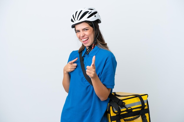 Mulher de entrega jovem com mochila térmica isolada no fundo branco, apontando para a frente e sorrindo