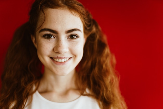 Foto mulher de escola ruiva com olhos castanhos e um sorriso aberto