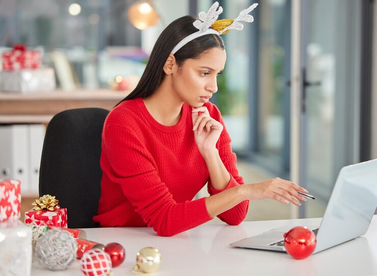 Foto mulher de escritório natal e laptop com ideias de planejamento ou pensando em dar presentes para o papai noel secreto trabalhador ou redator lendo ou pesquisando no computador para newsletter de redação em feriados festivos