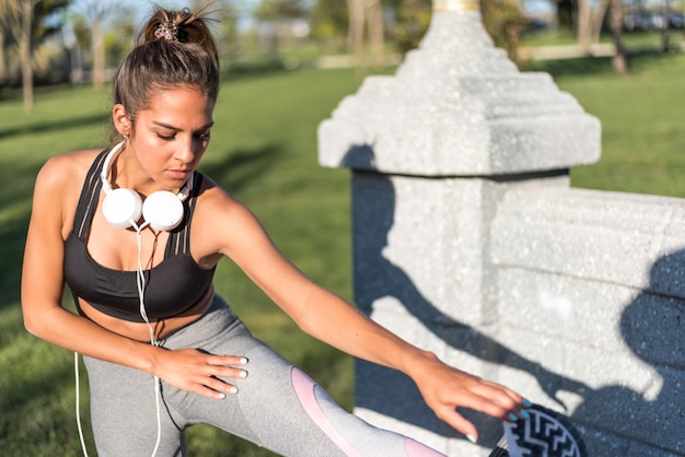 Mulher de esporte fazendo exercícios de gramado e alongamento na grama ao ar livre em uma música do parque