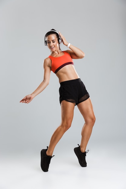 Mulher de esportes faz exercícios de esporte isolados dentro de casa.