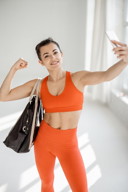 Mulher de esportes fazendo selfie na academia