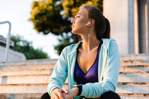 Foto mulher de esportes no parque ao ar livre, ouvindo música.