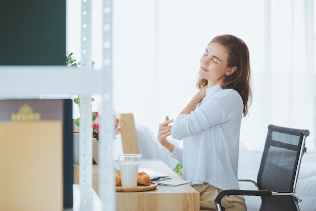 Foto mulher de estilo de vida trabalhando digitando no laptop na sala elegante em casa