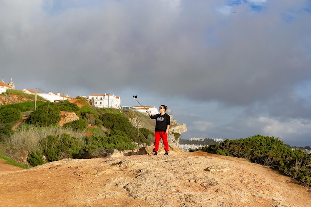 Mulher de férias tirando foto com bastão de selfie turista fotografando com telefone inteligente