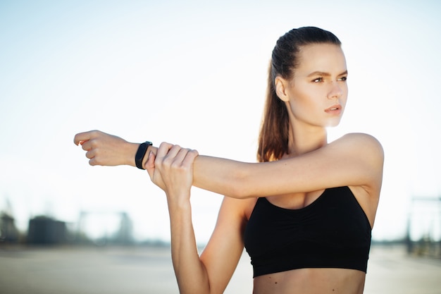 mulher de fitness, esticando os braços