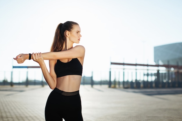 mulher de fitness, esticando os braços