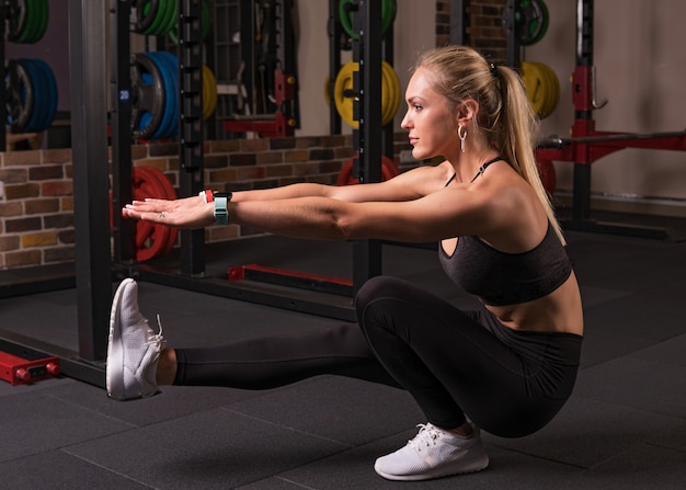 Mulher de fitness fazendo agachamento de pistola