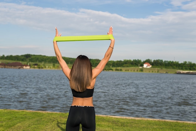 Mulher de fitness fazendo exercícios de treinamento ao ar livre no parque de verão. Estilo de vida saudável do esporte do conceito.