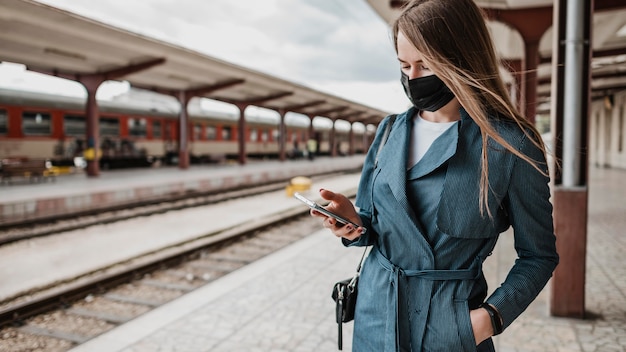 Foto mulher de frente para a estação ferroviária