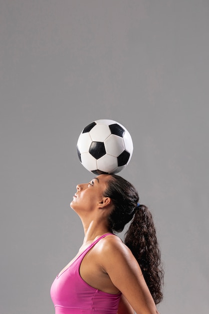 Foto mulher de futebol fazendo truques com bola