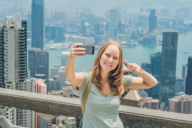 Mulher de Hong kong victoria Peak tirando foto de selfie stick com smartphone apreciando a vista