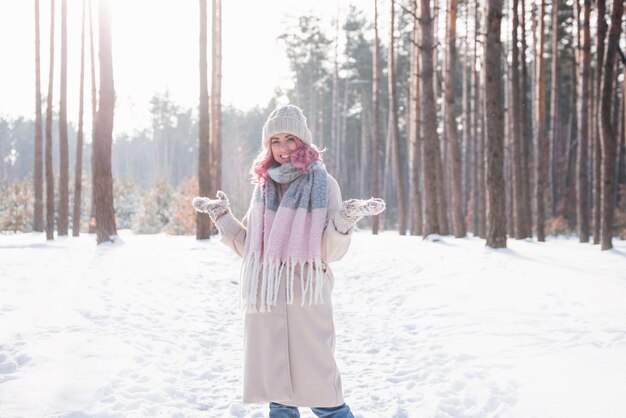 Foto mulher de inverno olhando feliz e sorrindo ao ar livre na neve em um dia frio de inverno