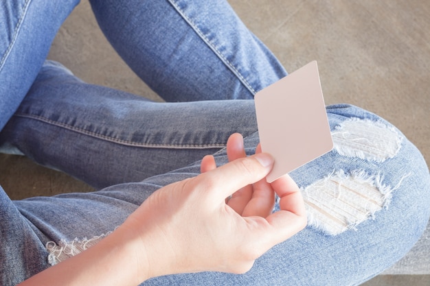 Mulher de jeans rasgados sentado no chão