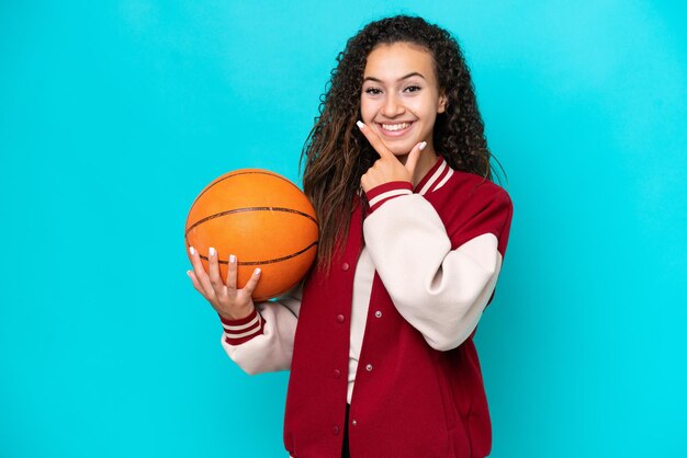 Foto mulher de jogador de basquete árabe isolada em fundo azul feliz e sorridente