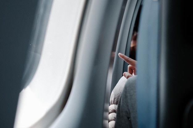 Mulher de mão na janela de um avião