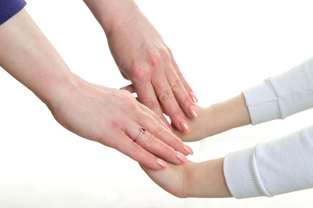 Mulher de mãos dadas menina isolada no fundo branco