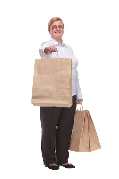 Mulher de meia idade alegre e sorrindo muito animada carregando sacolas de compras