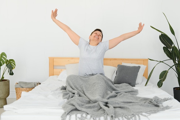 Mulher de meia idade atraente acordando na cama