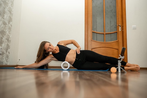 Mulher de meia idade bem parecida com instrutora de fitness de cabelo comprido em roupas esportivas pretas fazendo