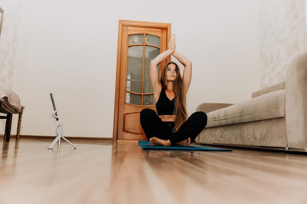 Mulher de meia idade bem parecida com instrutora de fitness de cabelo comprido em roupas esportivas pretas fazendo