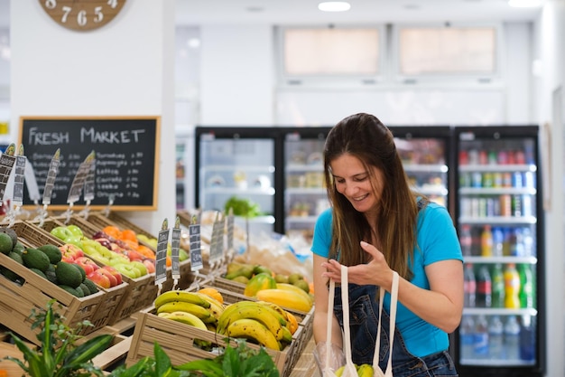 Mulher de meia idade comprando frutas e legumes