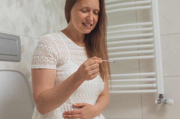 Mulher de meia idade confusa com teste de gravidez