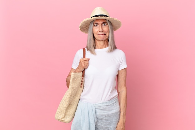 Mulher de meia-idade de cabelo branco parecendo perplexa e confusa. conceito de verão