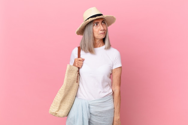 Mulher de meia-idade de cabelo branco se sentindo triste, chateada ou com raiva e olhando para o lado. conceito de verão