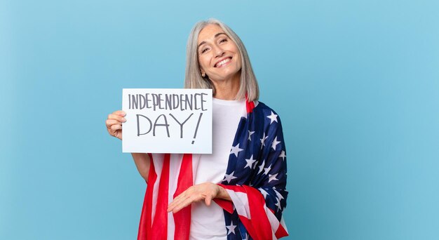 Mulher de meia-idade de cabelo branco sorrindo alegremente, sentindo-se feliz e mostrando um conceito. conceito do dia da independência