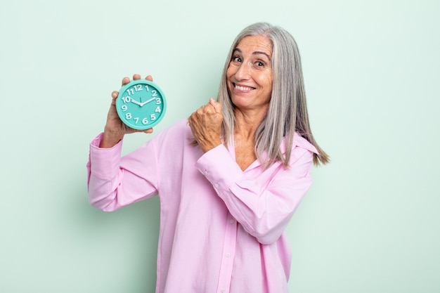 Foto mulher de meia-idade de cabelos grisalhos se sentindo feliz e enfrentando um desafio ou comemorando. conceito de despertador