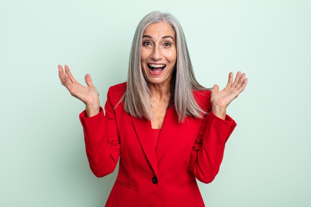Mulher de meia-idade de cabelos grisalhos se sentindo feliz e surpresa com algo inacreditável. conceito de mulher de negócios sênior