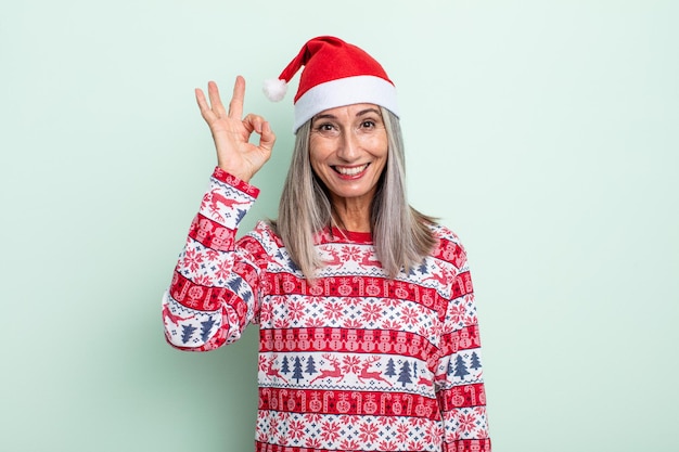Mulher de meia-idade de cabelos grisalhos se sentindo feliz, mostrando aprovação com um gesto certo. conceito de natal