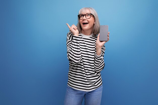 Mulher de meia idade esbelta e bem cuidada segurando um smartphone com uma maquete em um fundo brilhante
