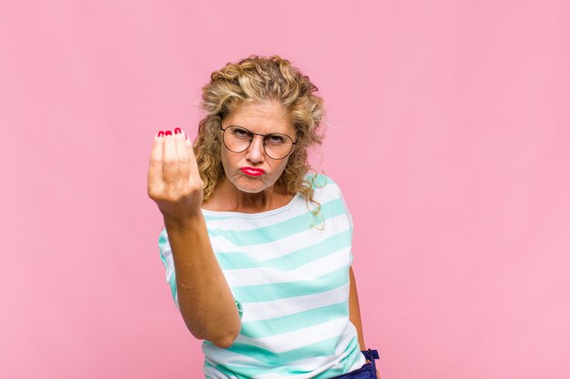 Mulher de meia idade fazendo capice ou gesto de dinheiro, mandando você pagar suas dívidas!