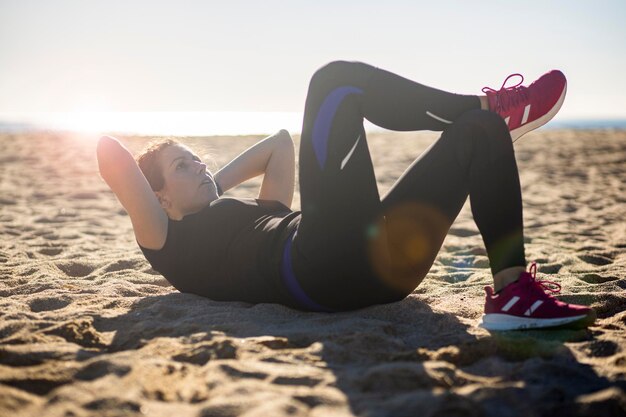 Foto mulher de meia-idade fazendo exercício na praia