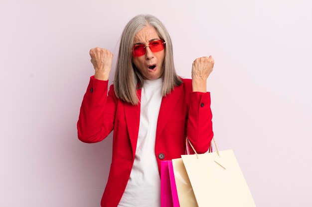 Mulher de meia idade gritando agressivamente com um conceito de compras de expressão de raiva