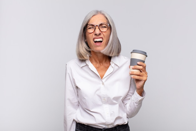Mulher de meia-idade gritando agressivamente, parecendo muito zangada, frustrada, indignada ou irritada, gritando sem conceito de café